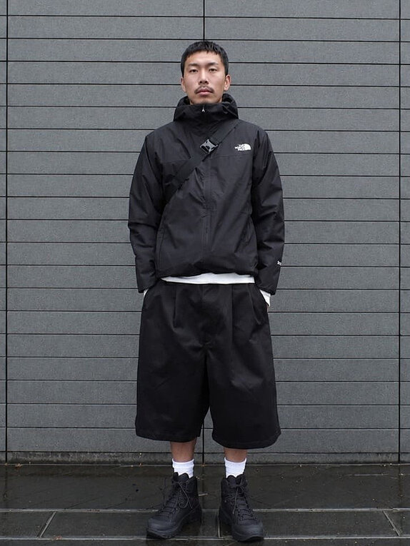 ゴールドウインオンラインストア公式 | STAFF PICKS AUTUMN OUTERWEAR STYLE | ブラックカラーのフード付きシェルジャケットを着用したルック。防風性と透湿性を備えたミニマルなデザインで街歩きやアウトドアに適したコーディネート。