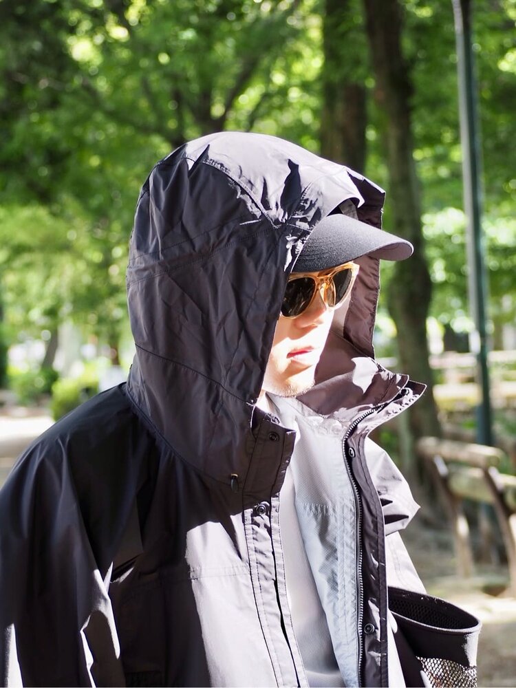 ゴールドウインオンラインストア公式 | STAFF STYLE | ブラックの防水レインポンチョはフードをかぶり、キャップを合わせて。サングラスもかけて、雨が降った日の視界も快適に。