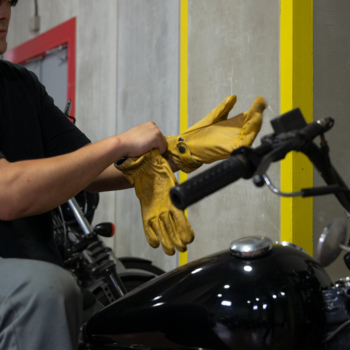 ジョン・ドゥーバイクにまたがってコヨーテ レザーグローブ ヴィンテージイエローを装着中の写真